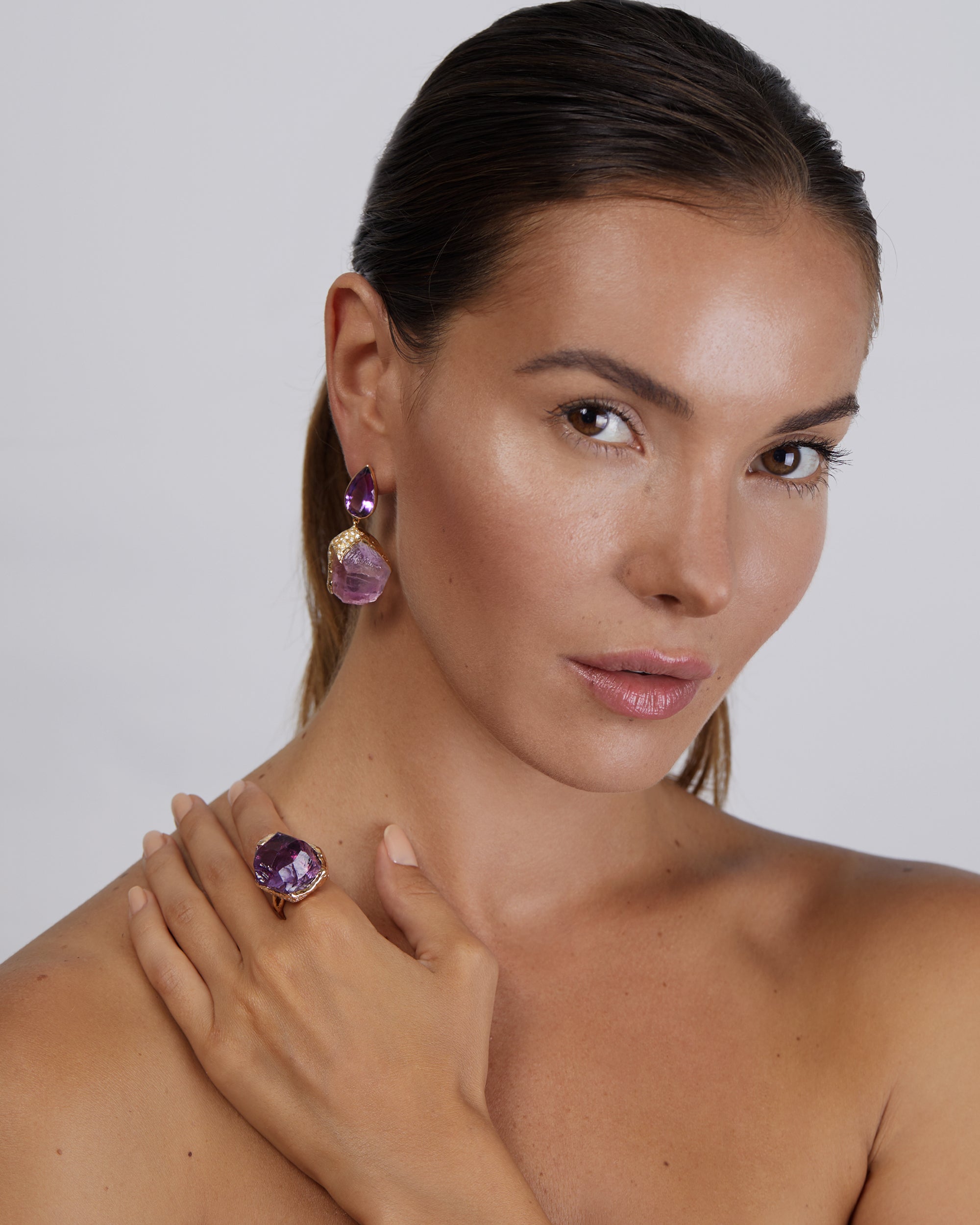 portrait of a woman wearing a recycled 18K Rose Gold amethyst ring alongside matching drop earring 
