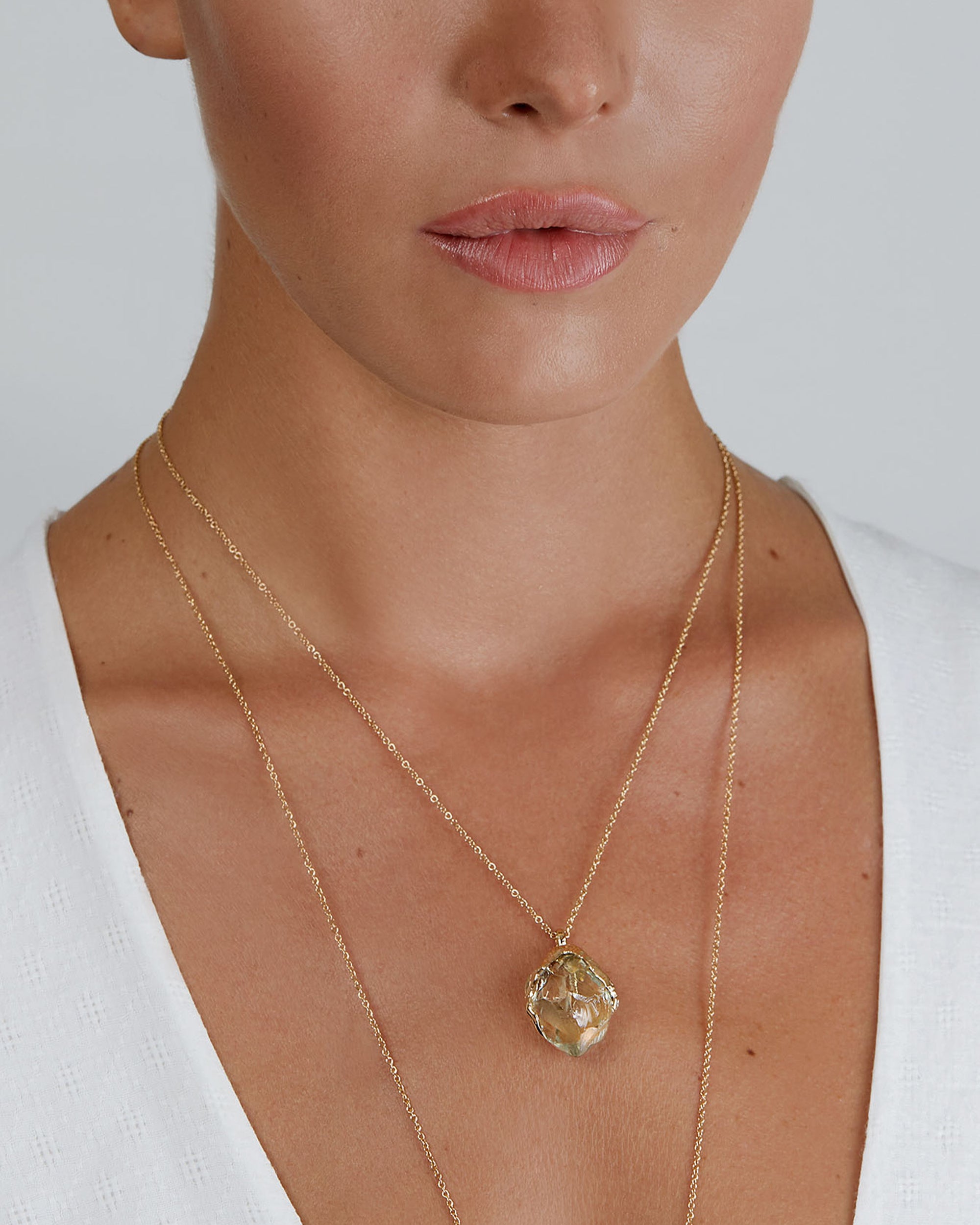 Portrait close-up of model wearing the short Natalie Dissel 18K yellow gold raw Prasiolite pendant necklace, Gem Rocks collection.