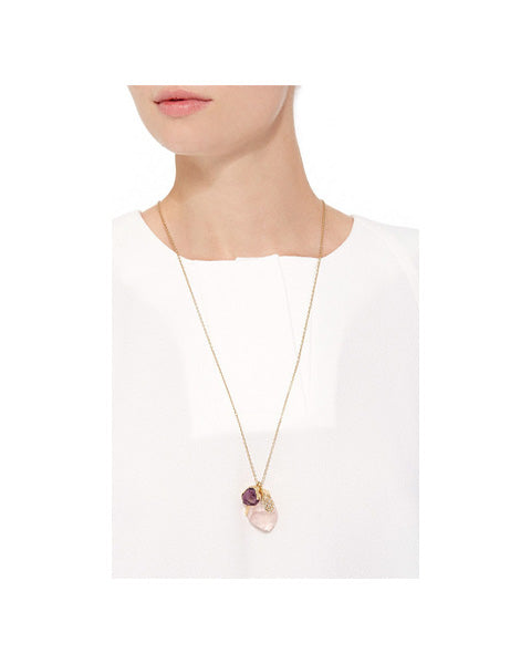 Model wearing long Natalie Dissel 18K yellow gold chain necklace with raw Rose Quartz, Amethyst, and diamond pendant against a white top, Rough Rocks collection.
