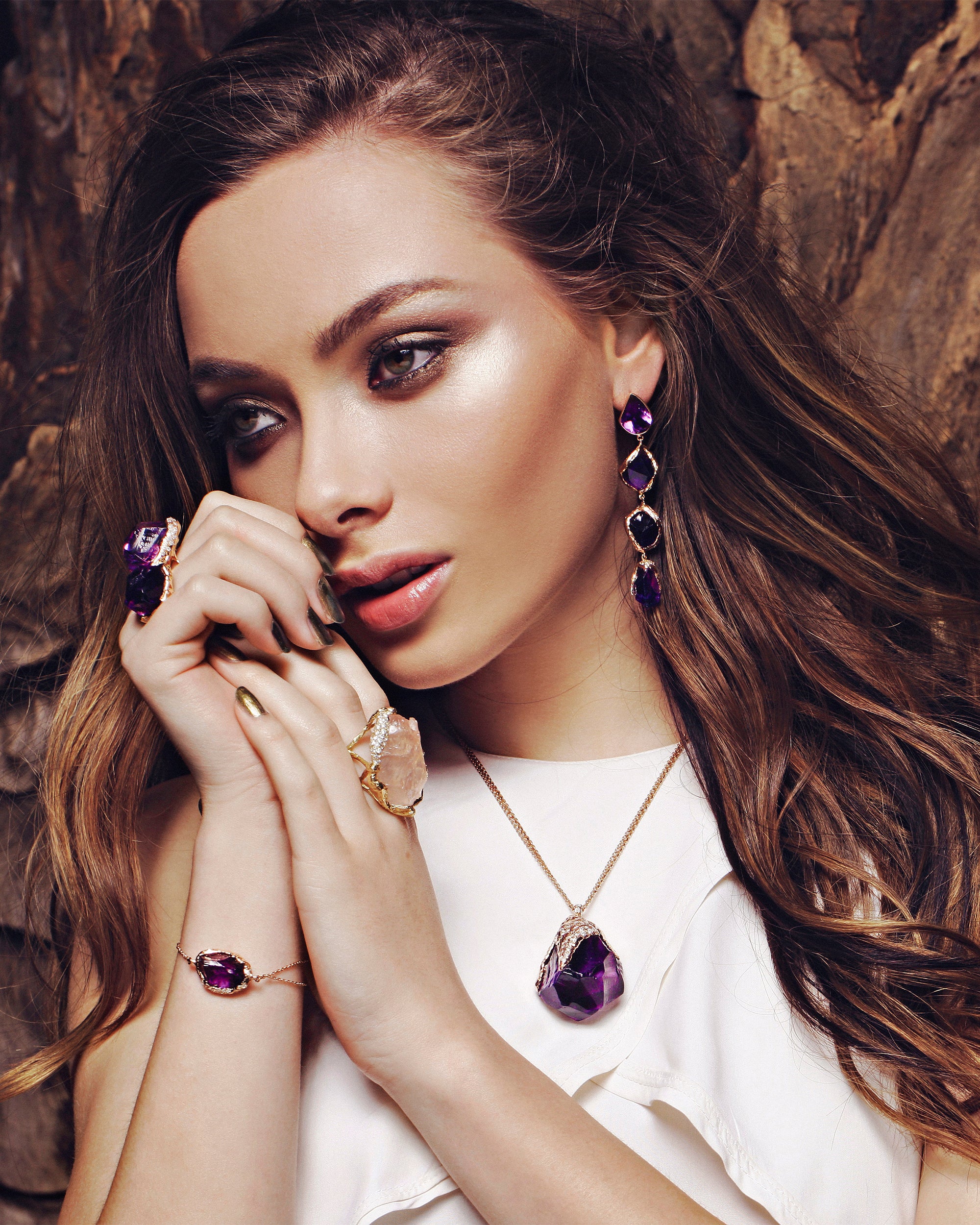 Model styled wearing the Natalie Dissel 18K yellow gold raw Rose Quartz ring alongside raw gemstone drop earrings, bracelet, and pendant.