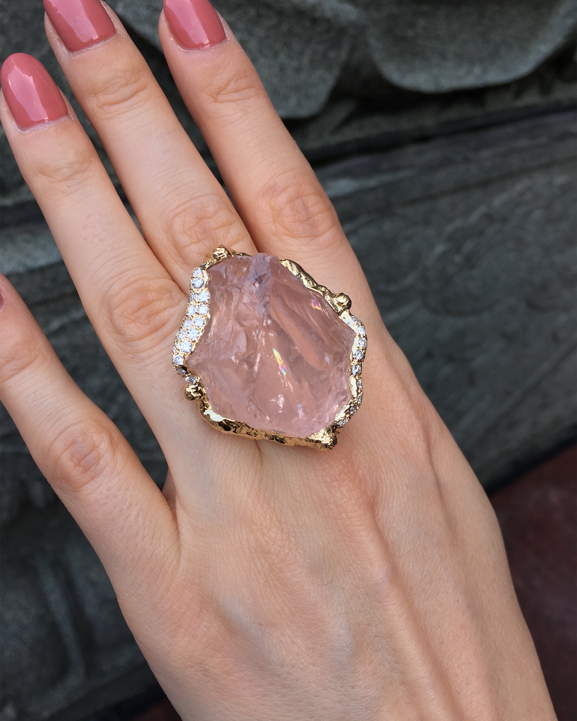 op view of the Natalie Dissel 18K yellow gold raw Rose Quartz ring worn on hand, highlighting the diamond-encrusted setting and natural gemstone.