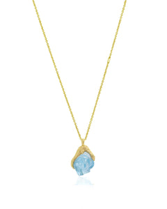 Front view of Natalie Dissel fine 18K yellow gold chain holding an uncut Sky Blue Topaz gemstone pendant set in molten gold, Gem Rocks collection.